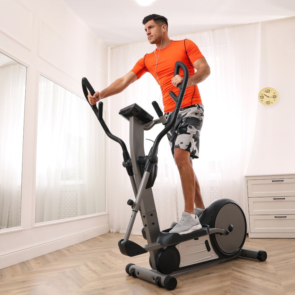 Man exercising on aelliptical machine in a home setting